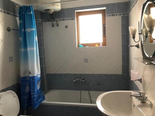 a bathroom with a bath tub and a sink at Villa 151 in Sarandë