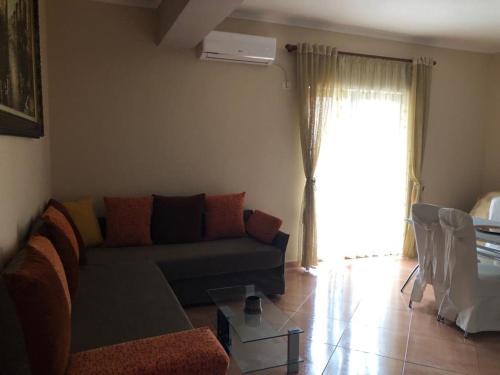 uma sala de estar com um sofá e uma janela em Villa 151 em Saranda