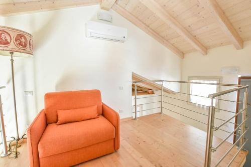 pomarańczowe krzesło w pokoju ze schodami w obiekcie Casa Dolce w mieście Luino
