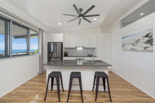 a kitchen with a large island with two stools at SEA-Renity II in Townsville