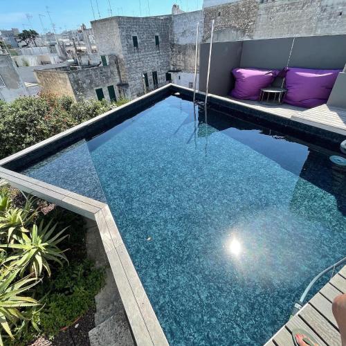 a swimming pool on the roof of a building at Bartago Luxury House in Ostuni
