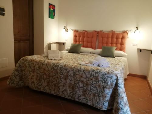a bedroom with a large bed with an orange headboard at B&B 8380 Saturnia Terme in Saturnia