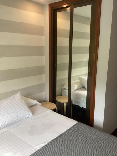 a bedroom with a bed and a mirror at Saudade Hostal Cafetería in A Coruña