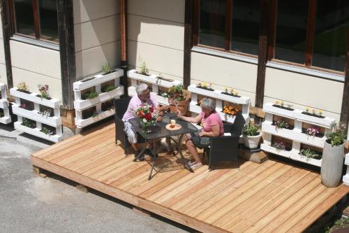 two people sitting at a table on a deck at BnB Le Loft Im Fang in Im Fang