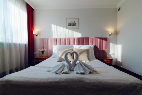 una camera da letto con un letto con due asciugamani sopra di Hotel Victoria a Wejherowo