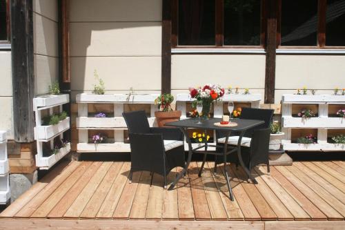 a table and chairs on a patio with flowers at BnB Le Loft Im Fang in Im Fang