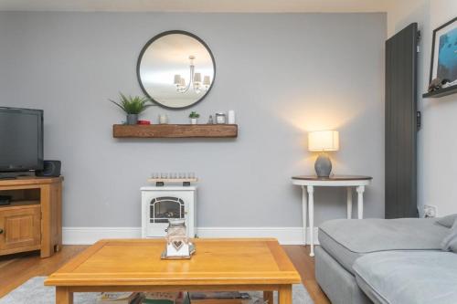 a living room with a table and a mirror at Pinecones in Valley
