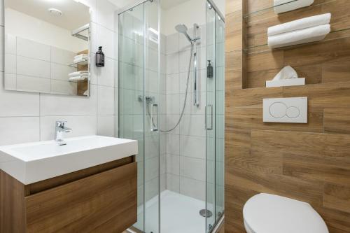 een badkamer met een douche, een wastafel en een toilet bij OREA Spa Hotel Bohemia Mariánské Lázně in Mariánské Lázně