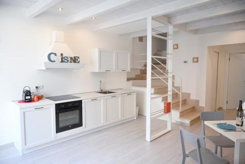 a kitchen with white cabinets and a spiral staircase at Il b&b di Alice in Monopoli