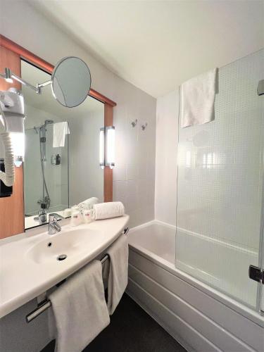 a bathroom with a sink and a shower and a tub at Ibis Ripollet in Ripollet