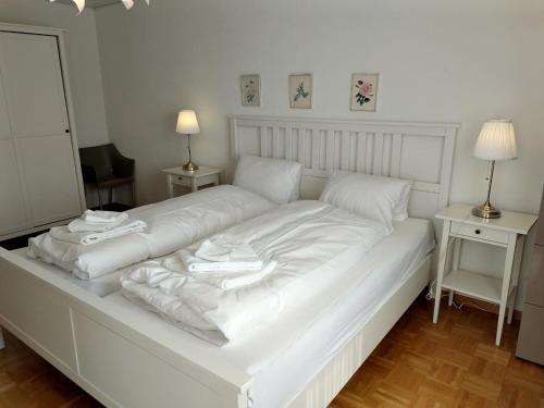 1 cama blanca grande con sábanas y almohadas blancas en Royal 41, en Leukerbad