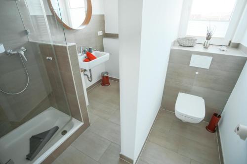 ein Bad mit einer Dusche, einem WC und einem Waschbecken in der Unterkunft Ferienwohnung Nr. 9 in Borkum