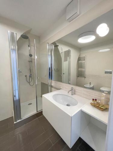 a white bathroom with a sink and a shower at Il b&b di Alice in Monopoli