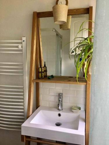 une salle de bain avec un lavabo blanc et un miroir dans l'établissement Agréable maison à 500 m de la plage !, à Saint-Quay-Portrieux