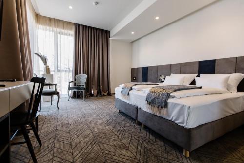 ein Hotelzimmer mit einem großen Bett und einem Schreibtisch in der Unterkunft Hotel Buna Mostar in Buna