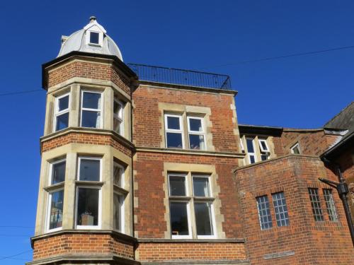 a brick building with a tower on top of it at The Vicarage Apartment in Hunstanton