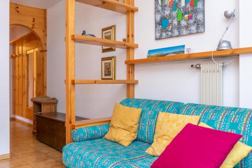 a living room with a blue couch and wooden shelves at Casa Maura in Soraga