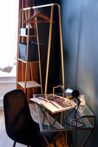 a glass table and a chair and a shelf at Hôtel Le Tiburon in Cherbourg en Cotentin