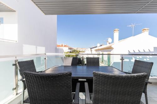 a table and chairs on the balcony of a house at Numar AI By ALGARVEMANTA in Vila Nova De Cacela