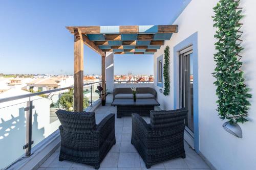 a patio with chairs and a table on a balcony at Numar AI By ALGARVEMANTA in Vila Nova De Cacela