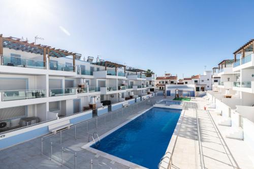 an image of an apartment building with a swimming pool at Numar AI By ALGARVEMANTA in Vila Nova De Cacela