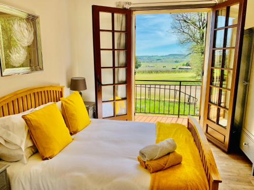 une chambre avec un lit et une grande fenêtre dans l'établissement Les Grands Bois, à Pomport