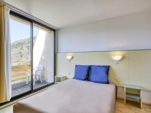 a bedroom with a bed and a large window at Vacancéole - Le Domaine de Confolant in Miremont