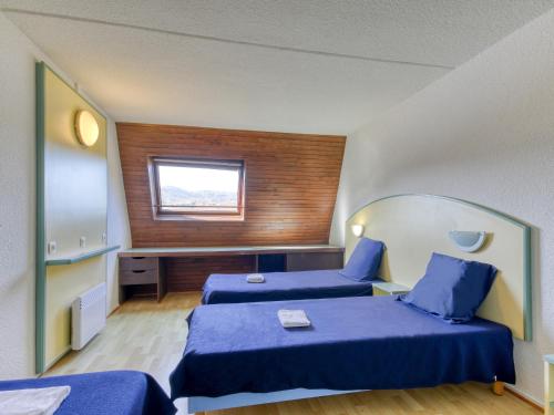 a hotel room with two beds and a window at Vacancéole - Le Domaine de Confolant in Miremont