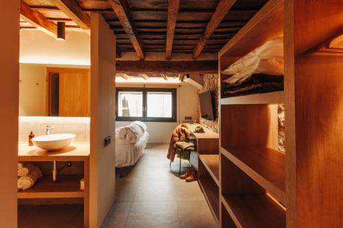 een badkamer met een wastafel en een bed in een kamer bij Hotel Boutique El Mariner in Camprodon