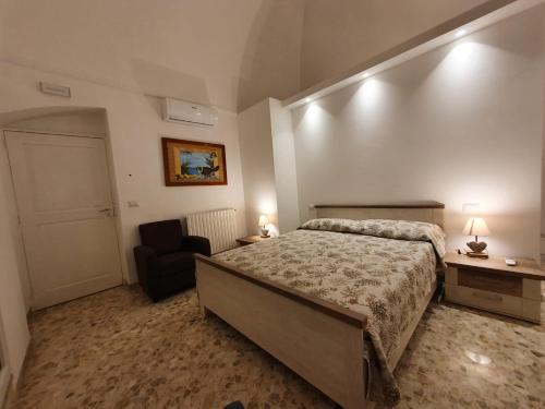 - une chambre avec un grand lit et une chaise dans l'établissement Stella Maris, à Conversano