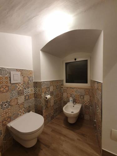 a bathroom with a toilet and a sink and a tv at Stella Maris in Conversano