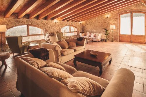 a large living room with couches and a table at Mas Vilar, relax, nature and slow Exclusive Only 6 rooms in Arbúcies