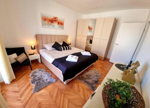 a bedroom with a bed and a chair in a room at SING APARTMENT in Zadar