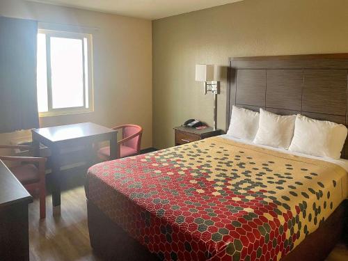 une chambre d'hôtel avec un lit et un bureau dans l'établissement Econo Lodge Inn & Suites Corning, à Corning