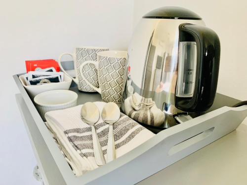 a white shelf with a coffee pot and utensils at Les Grands Bois in Pomport