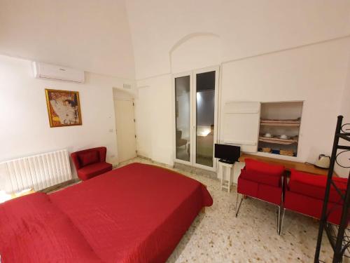 - une chambre avec un lit rouge et une chaise rouge dans l'établissement Stella Maris, à Conversano