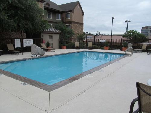 a large swimming pool with chairs and a building at Sonesta ES Suites San Antonio Northwest Medical Center in San Antonio