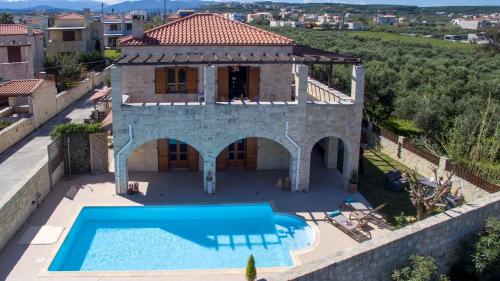 einen Luftblick auf eine Villa mit einem Pool in der Unterkunft World Villa in Tavronítis