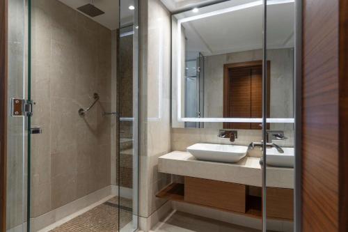 a bathroom with a sink and a shower and a mirror at Radisson Blu Hotel, Juba in Juba