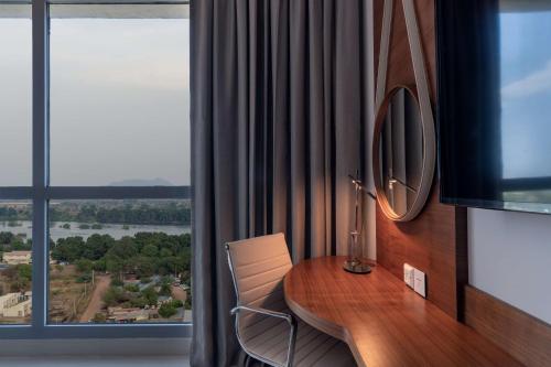 a room with a table with a mirror and a window at Radisson Blu Hotel, Juba in Juba