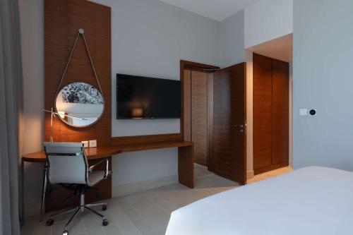 a bedroom with a desk and a tv and a bed at Radisson Blu Hotel, Juba in Juba