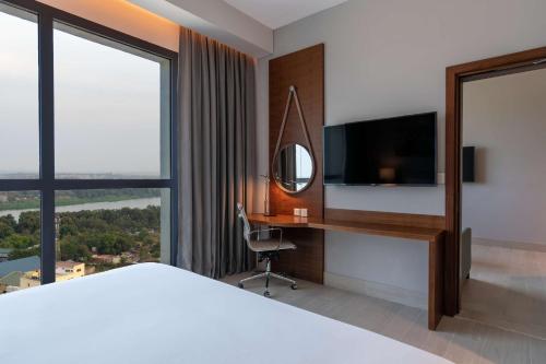 a bedroom with a bed and a desk with a television at Radisson Blu Hotel, Juba in Juba