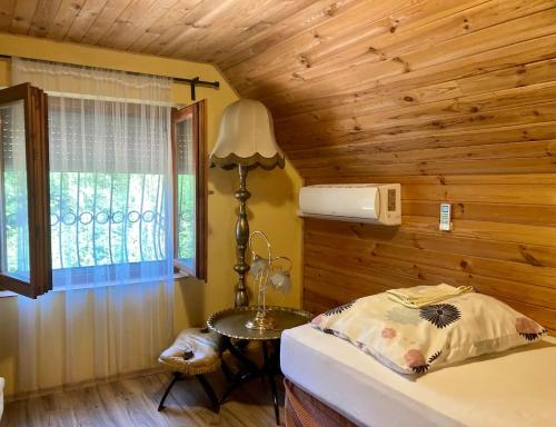 Schlafzimmer mit einem Bett, einem Tisch und einem Fenster in der Unterkunft Harcsáztat-Lak in Tiszaderzs