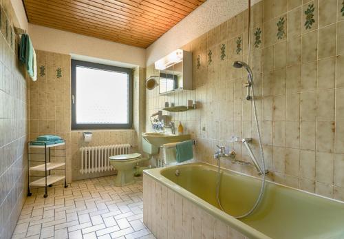 ein Badezimmer mit einer Badewanne, einem WC und einem Waschbecken in der Unterkunft Drei Tannen - Wohnung 04 - Apartmenthaus, Titisee, nahe Badeparadies in Titisee-Neustadt