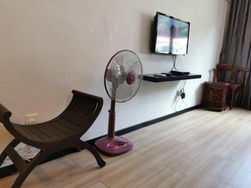 Cette chambre comprend une chaise et un ventilateur. dans l'établissement C 13 Lot 10 Pangkor Leisure Beach Studio, à Île de Pangkor
