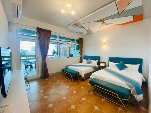 a bedroom with two beds and a balcony at 墾丁涵寓包棟民宿 in Hengchun South Gate