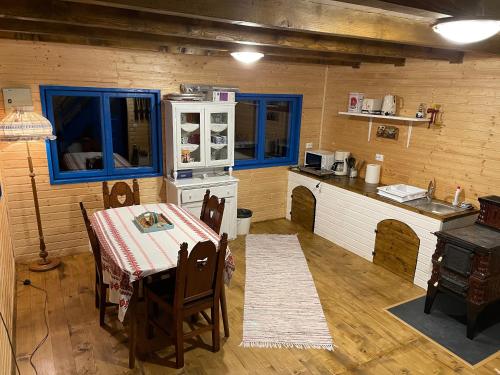 eine Küche mit einem Tisch und einem Herd im Zimmer in der Unterkunft Casa Brună in Băile Olăneşti