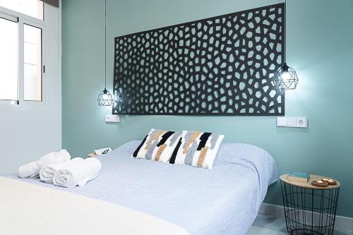 una camera blu con un letto e asciugamani di Puerta de Purchena - Lux&Cool - apartamento a Almería