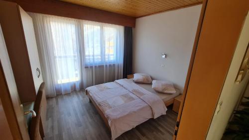 a small bedroom with a bed and a window at Pension Taverne in Grächen