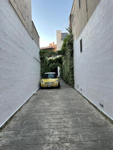 a yellow car parked in a alley next to a building at Bartago Luxury House in Ostuni